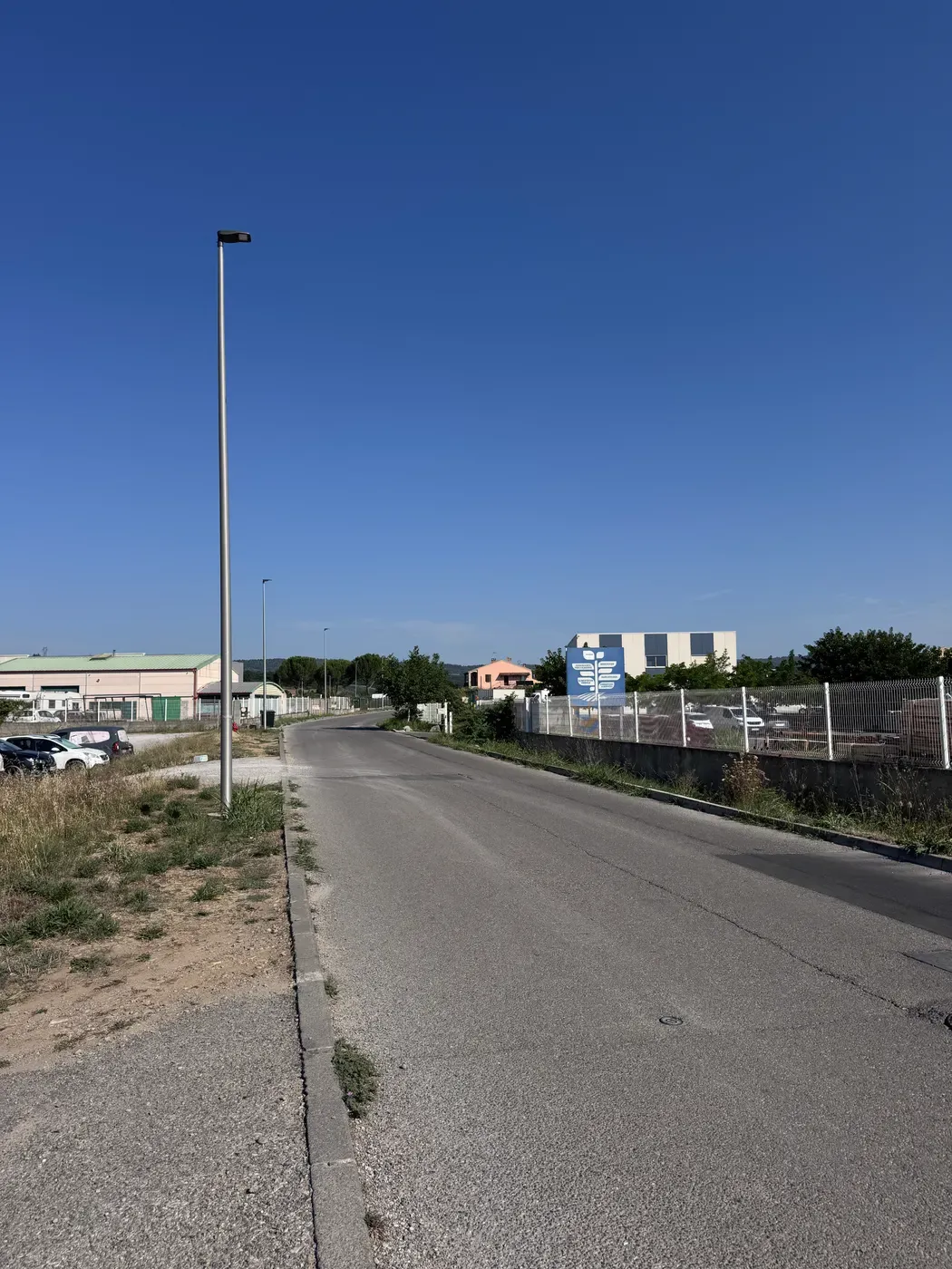 Une avenue de Sainte-Tulle bordée de bâtiments d’activité, en direction de la zone d’activité.