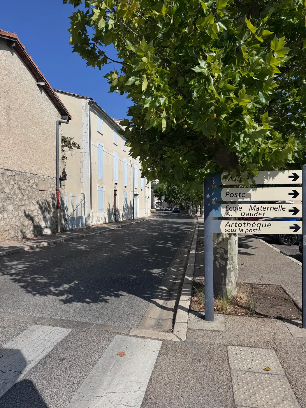 Un panneau directionnel à Volx indiquant la mairie, la poste, l’école maternelle et l’artothèque.